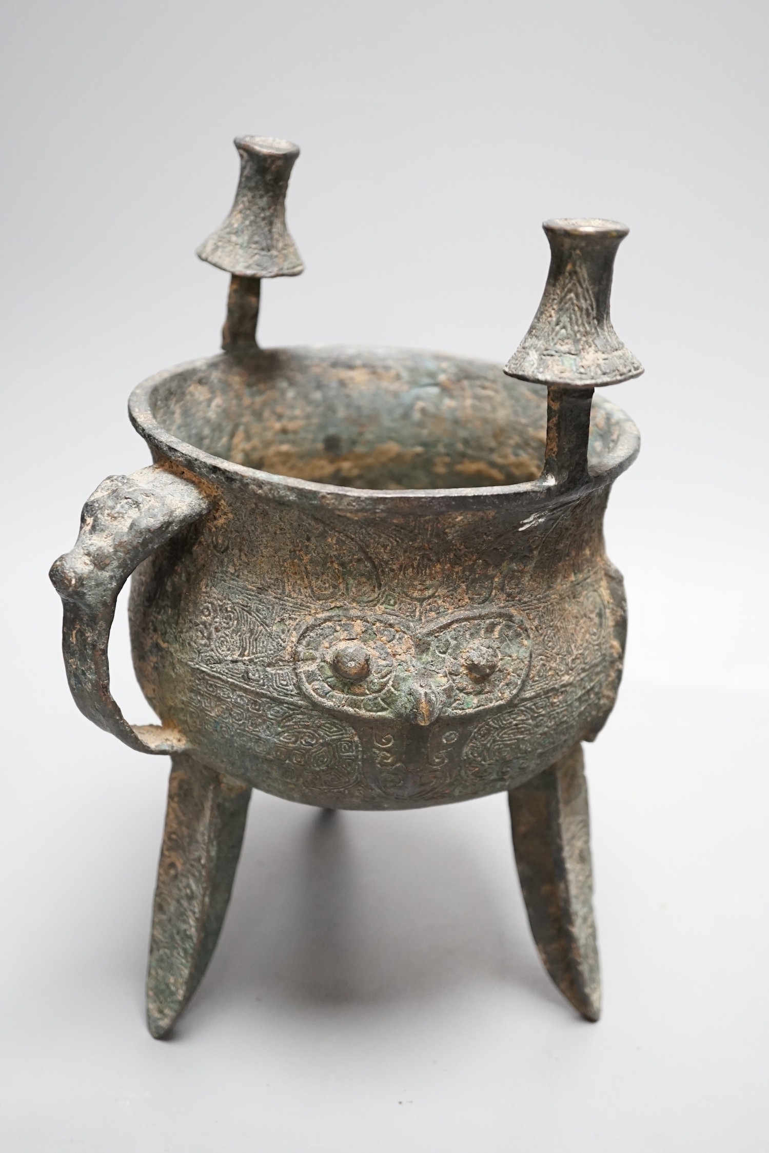 A Chinese green and russet jade belt buckle, an archaistic bronze tripod vessel and a figural bronze. Tallest 25cm